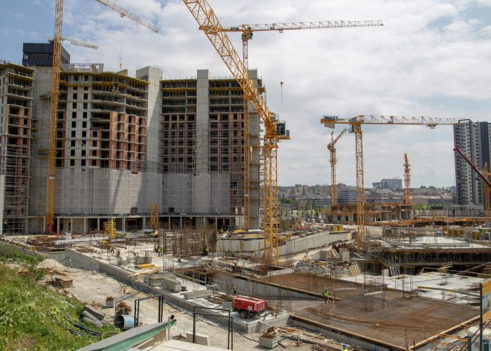 View of a bustling urban construction site with cranes and high-rise buildings.
