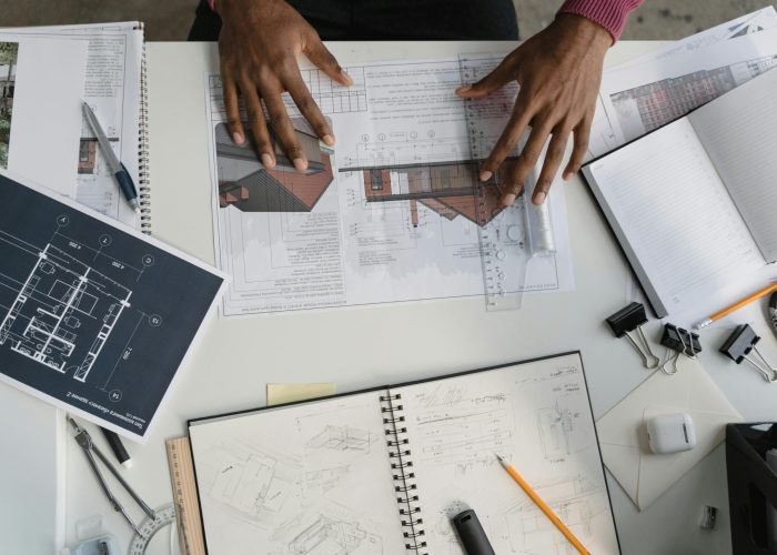 Architect analyzing blueprints and sketches at a modern workspace.
